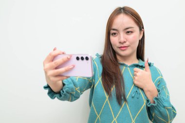 Genç Asyalı bir kadının cep telefonuyla beyaz arkaplan üzerindeki stüdyo portresi