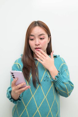 Genç Asyalı bir kadının cep telefonuyla beyaz arkaplan üzerindeki stüdyo portresi