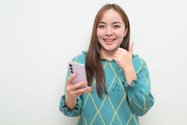 Genç Asyalı bir kadının cep telefonuyla beyaz arkaplan üzerindeki stüdyo portresi