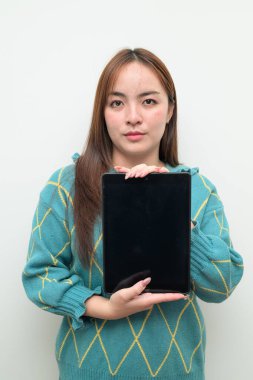 Tablet bilgisayar kullanan Asyalı genç bir kadının beyaz arkaplan üzerindeki stüdyo portresi