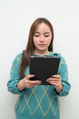 Tablet bilgisayar kullanan Asyalı genç bir kadının beyaz arkaplan üzerindeki stüdyo portresi