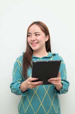 Tablet bilgisayar kullanan Asyalı genç bir kadının beyaz arkaplan üzerindeki stüdyo portresi
