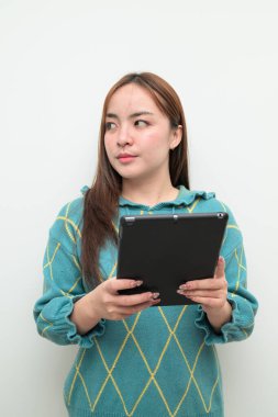 Tablet bilgisayar kullanan Asyalı genç bir kadının beyaz arkaplan üzerindeki stüdyo portresi