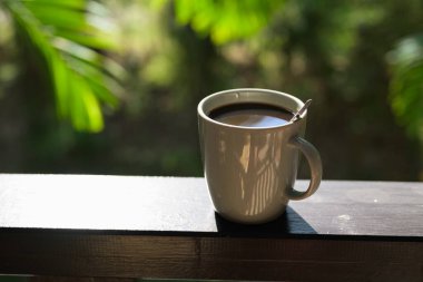 Tropikal yapraklı kahve fincanı sakin bir sabah yaşam tarzını ve günlük rutinini temsil ediyor..
