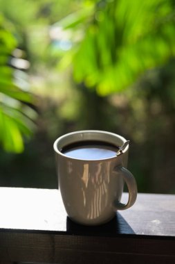 Tropikal yapraklı kahve fincanı sakin bir sabah yaşam tarzını ve günlük rutinini temsil ediyor..