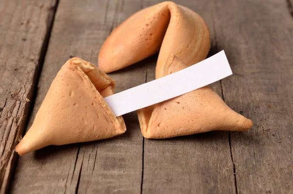 Cracked fortune cookie on a wooden table — Stock Photo, Image