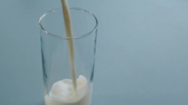 Bir bardak taze organik süt dökülüyor. Sağlıklı gıda konsepti