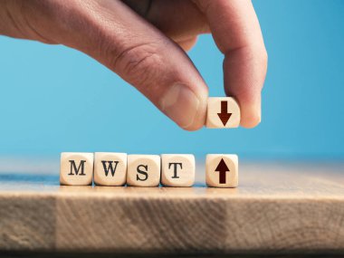 Bir iş adamı, tahta küpü yukarı ok ile aşağı ok ile tahta küpü takas eder. KDV indirimli Alman ekonomik uyarıcı paketi.