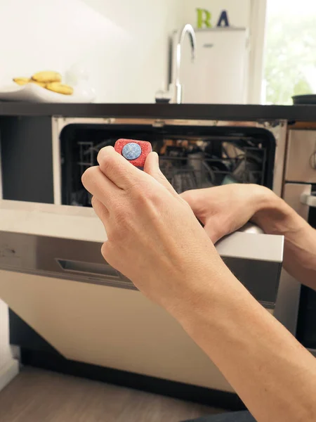 一位中年男子给洗碗机配备了一个清洁标签和清洁概念 — 图库照片