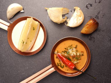 Baharatlı biber sosu. Koyu taş bir masada malzemelerle.