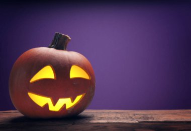 Cadılar bayramı balkabağı oyulmuş Jack o fener kırsal bir ahşap masada sisli, mesaj için yer var.