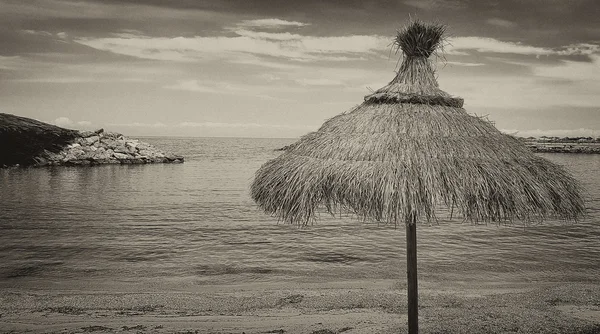 Sonnenschirm aus Stroh am Strand — Stockfoto
