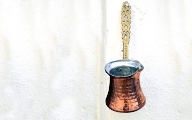 Old copper coffee pot hanging on the wall clipart