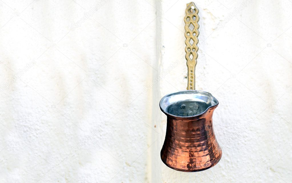 Old copper coffee pot hanging on the wall