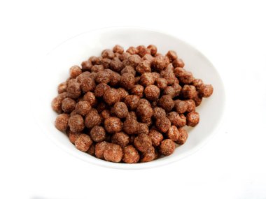 Bowl with chocolate corn balls on a white background
