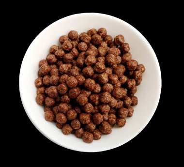Bowl with chocolate corn balls on a black background