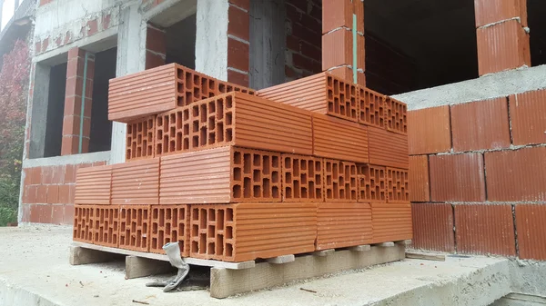 Several red perforated brick on pallet — Stock Photo, Image