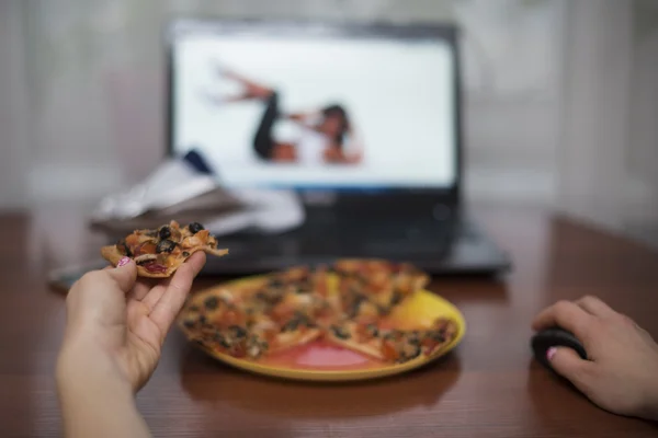 Ragazza mangiare pizza e guardare esercizio per la perdita di peso — Foto Stock