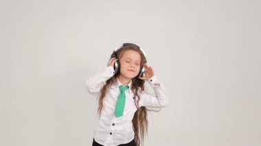 Küçük sevimli kız dans ve kulaklık ile müzik dinlemek
