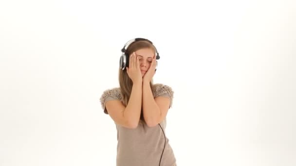 Joven chica bonita en los auriculares escuchando música — Vídeos de Stock