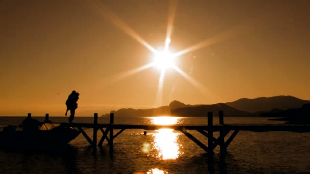 Pareja juguetona en puente al atardecer — Vídeos de Stock