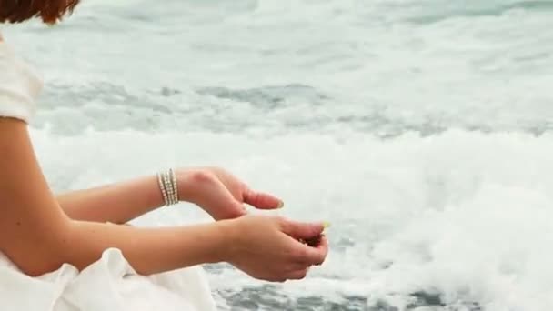 Mulher bonita jogando seixos no mar Negro sentado na praia — Vídeo de Stock