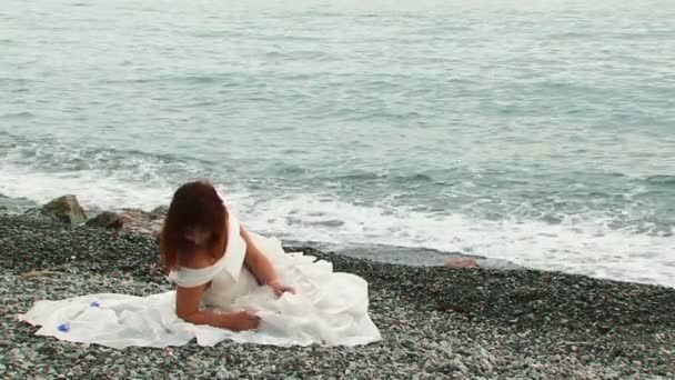 Mooie vrouw ontspannen op het strand van saaie dag — Stockvideo