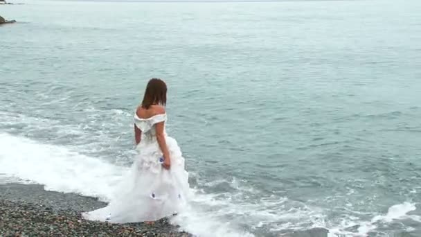 Schöne Frau im weißen Kleid, die ins Meer geht — Stockvideo