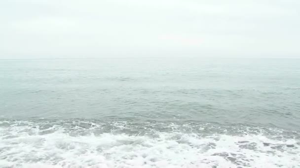 Mulher bonita em vestido branco andando ao longo da praia em ondas — Vídeo de Stock