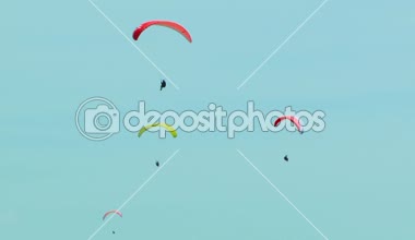 Dört paraşütler yavaş yavaş mavi gökyüzünde uçan