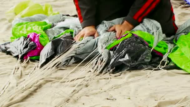 Man Wrapping Parachute Shroud Lines On The Ground — Stock Video