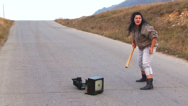 Mad Woman With Club Smashing a TV-set At Road — Stock Video