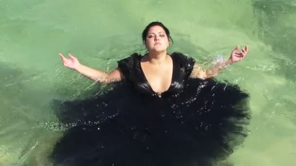 Kvinnan i svart står på vattnet i sjön — Stockvideo