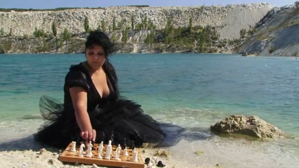 Πορτραίτο νεαρής γυναίκας στα μαύρα παίζοντας σκάκι — Αρχείο Βίντεο