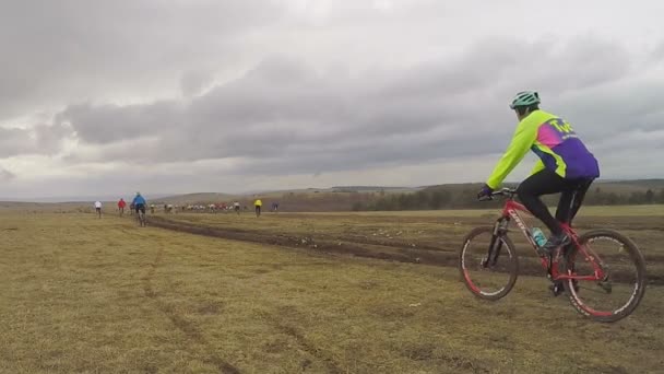 EDITORIAL. Jóvenes ciclistas moviéndose en el campo en el día aburrido — Vídeo de stock