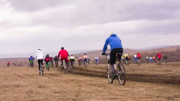 Redactie. Groep van jonge fietsers rijdt In veld met saaie dag — Stockvideo