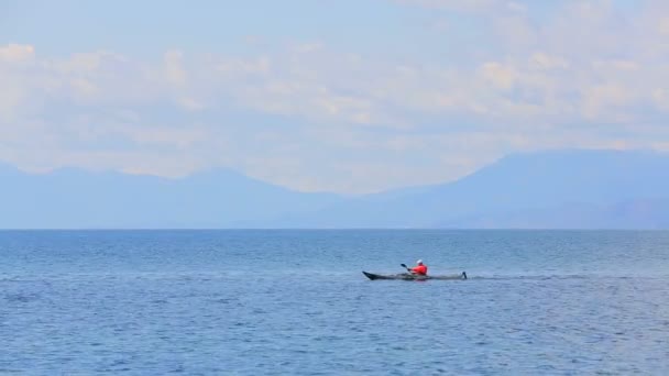 Человек плывет на каноэ в море — стоковое видео