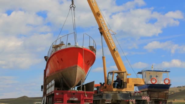Редакция. Работники подъема праздничный крейсер на берегу моря с помощью кран-машины — стоковое видео