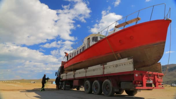 Redactionele. Mensen die werken tijdens het laden van de vakantie Cruiser op de vrachtwagen aan de kust — Stockvideo
