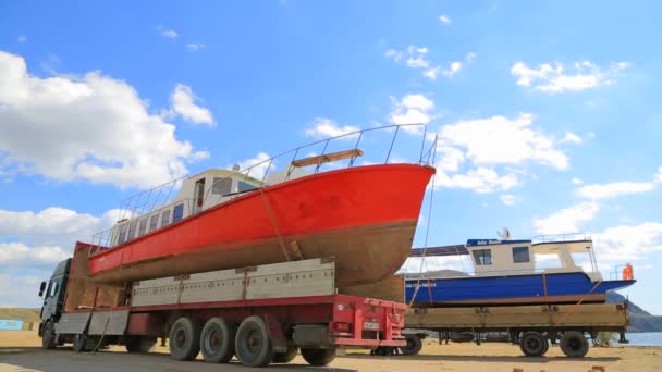 Editoriale. Deux camions avec voiliers à bord au bord de la mer — Video