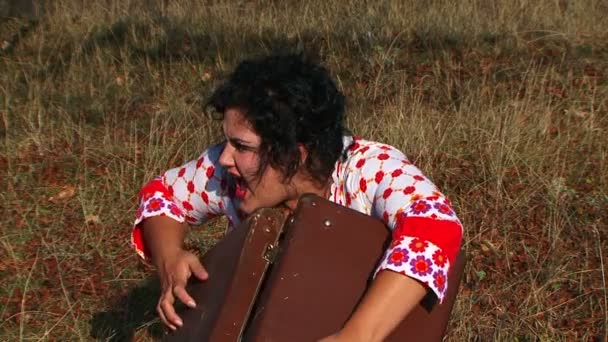 Folle sombre chevelu femme avec valise à la prairie à la nature — Video