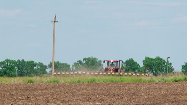 フィールドで作物を植えるシーダーとトラクター — ストック動画