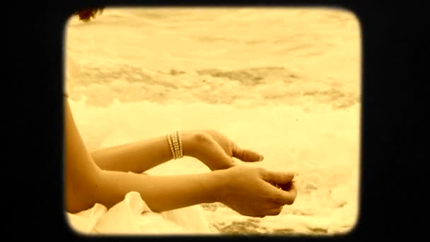 Young Woman Throwing Pebbles Into Black Sea Sitting on Beach — Stock video