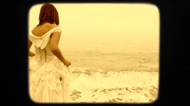 Piękna młoda kobieta w białej sukni chodzenie do morza — Wideo stockowe