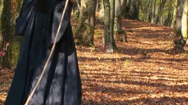 Kadın siyah kürk kuyruğu ile sonbahar orman halat üzerinde yürüme