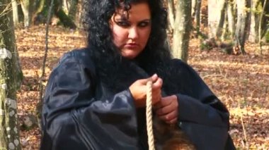 Kadın siyah sonbahar ormanda bir kürk kuyruğu ip bağlama