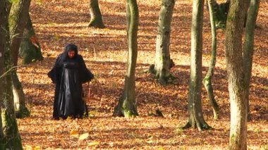Kadın siyah sonbahar ormanda yürüyüş