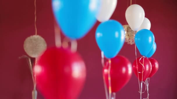 Bando de balões coloridos em fundo vermelho escuro — Vídeo de Stock