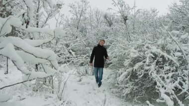 Genç adam kış ormanda yürüyüş