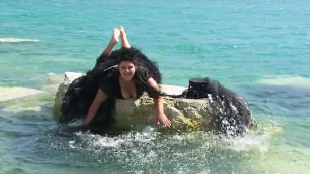 Frau im schwarz plätschernden Seewasser — Stockvideo